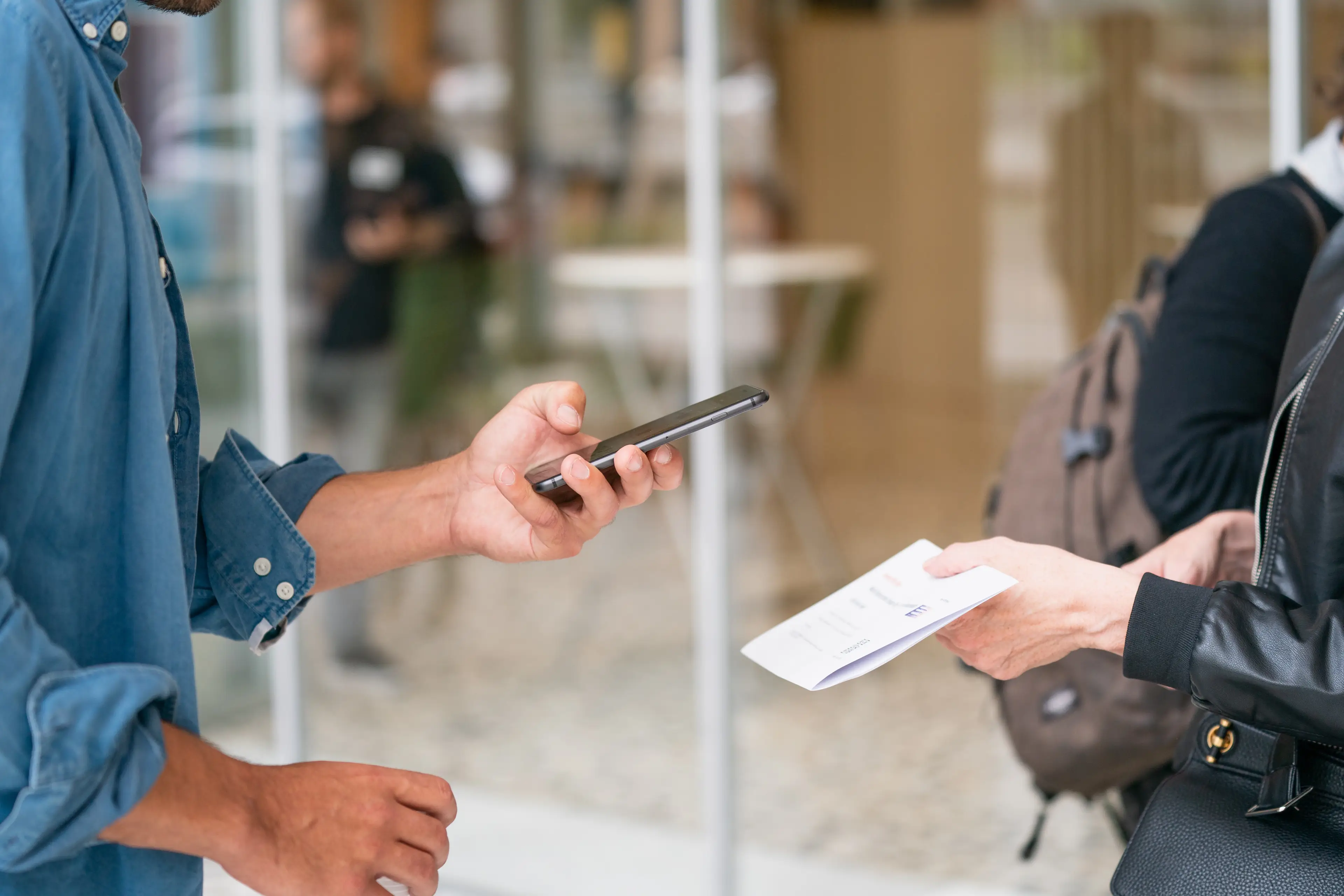 A person scanning a document held by another person